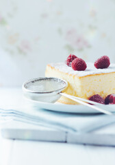 Measuring scoop with powder sugar and Piece of cheese cake on wooden background.	