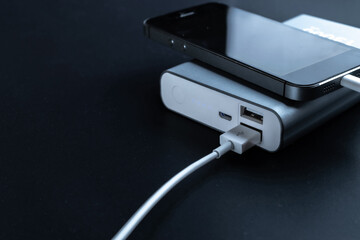 Charging phone. Portable powerbank with white usb cable for charger mobile phone or smartphone battery. Electronic devices concept.