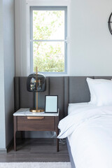 modern cozy white bedroom with side table lamp