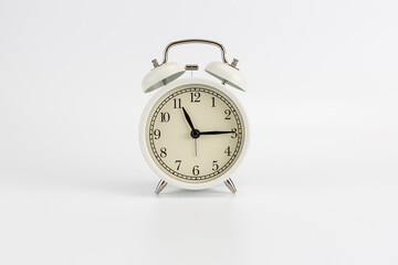 White retro clock alarm clock on white background shows 11:15 am or 11:15 pm or 23:15