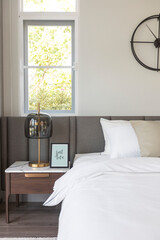 modern cozy white bedroom with side table lamp