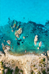 View from above, stunning aerial view of a green and rocky coastline bathed by a turquoise, crystal clear water.Sardinia, Italy.
