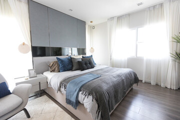 Stylish Bedroom and headboard with soft white and blue pillows setting,  cozy interior design.