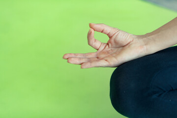 Hand of woman presents yoga practice style gesture, lotus pose, the basic for a newcomer