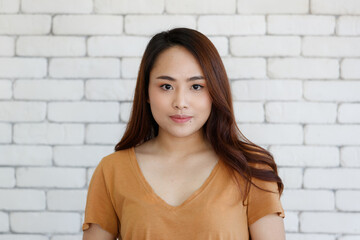 Young and beautiful healthy Asian woman with a mole on face and positive happy pose on a plain background. Concept for joy, proud, self-confident, and successful female in business and life - obrazy, fototapety, plakaty