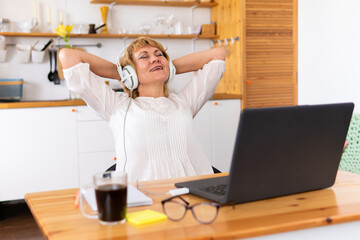 A fat woman is sitting at a table with a laptop.