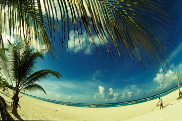 Plage mer des Caraïbes sable fin, mer bleue turquoise et ciel bleu, barque, bateau.