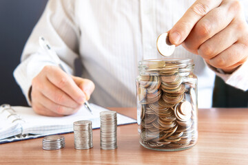 The coins are stored in a glass jar to accumulate finances.