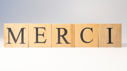 The word Merci was created from wooden cubes. aid organizations.