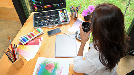 Top view of graphic art designer, creative desk with female holding coffee