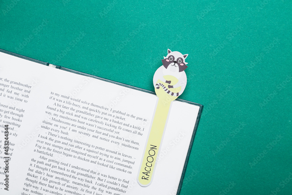 Wall mural Cute bookmark with book on color background