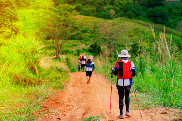 Trail runner, Asian woman wearing sportswear and equipment Practicing running and on a high mountain, running on a dirt path On a day when the sky is clear