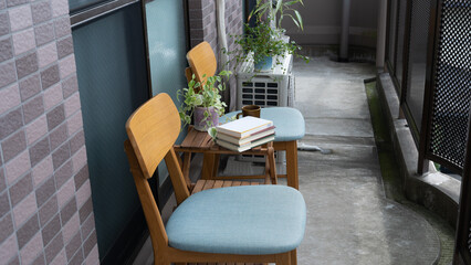 バルコニーで読書。日本のマンションのベランダ。椅子とテーブルと本。 - obrazy, fototapety, plakaty
