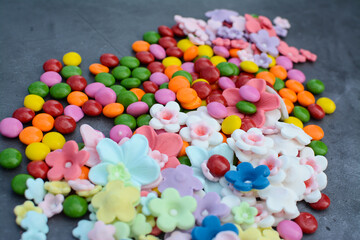 Fototapeta na wymiar small and colorful sweet candies on gray background