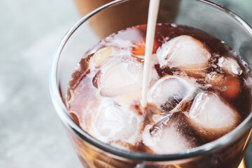 Fototapeta na wymiar Pouring of milk into glass of tasty iced coffee on table, closeup