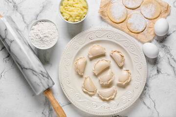 Composition with raw dumplings on light background