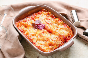 Baking dish with tasty tomato lasagna on light background