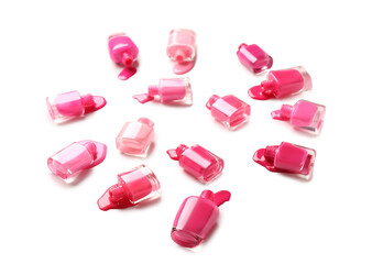 Overturned bottles of nail polishes on white background