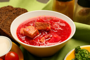 Bowl with tasty borscht on table