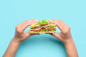 Deurstickers Female hands with tasty sandwich on color background © Pixel-Shot