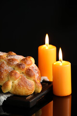 Bread of the dead and candles on dark background. Celebration of Mexico's Day of the Dead (El Dia de Muertos)