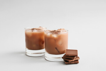 Glasses of tasty chocolate milk on white background