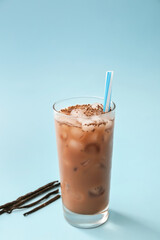 Glass of tasty chocolate milk and vanilla sticks on color background