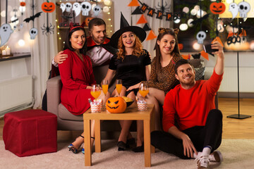 friendship, holiday and people concept - group of happy smiling friends in halloween costumes of...