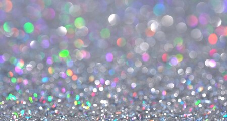 Magical festive shiny background for Christmas. Neon pastel bright magic unicorn rainbow abstract lights. Blurred colorful light dots. Dust or flying particles