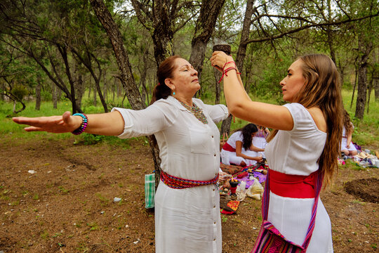 Woman Performing Temazcal Cleansing Ritual On Senior Female