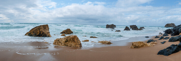 Grande plage de sable avec des rochers © jkphoto69
