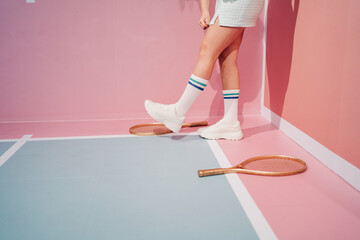 Crop player in sneakers with racket on tennis court