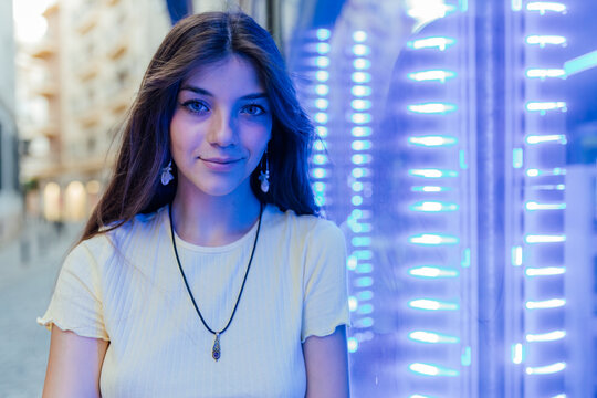 Sincere woman against neon lights on street