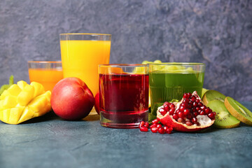 Glasses with healthy juice, fruits and vegetables on dark background
