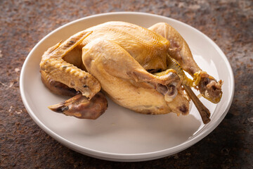 boiled chicken in simply ceramic plate on rusty texture background