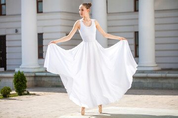 Fototapeta premium young ballerina dancing in the street