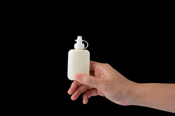 Hand holding a plastic bottle on black background