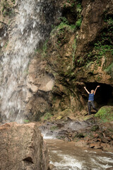 Small human watching at beautiful mountain waterfall