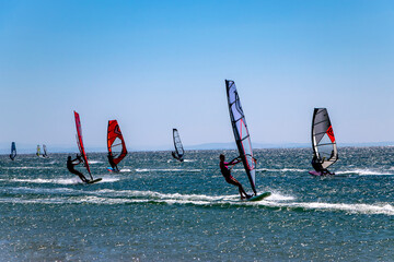 Kefalos beach, Gokceada, Turkey - 21-08-2021 colorful windsurfers on a windy day. Practicing wind...