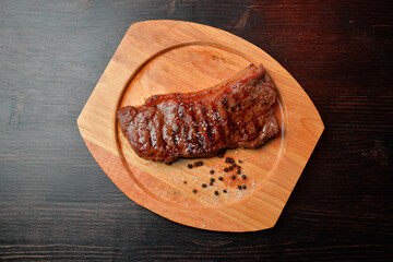 grilled steak on wooden board top view