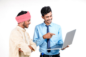 Fototapeta premium Indian bank officer or corporate government employee showing some information to farmer in laptop.
