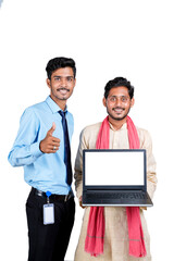 Young indian officer showing laptop screen with farmer on white background.