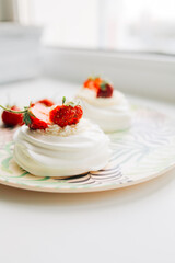 Sweet dessert, Pavlov's cake with butter cream and strawberries. Soft focus background, a place for text .