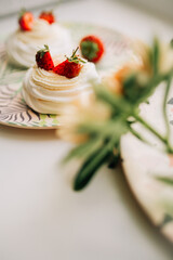 Sweet dessert, Pavlov's cake with butter cream and strawberries. Soft focus background, a place for text .