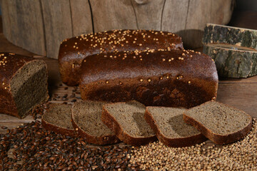 Dark sliced bread with seeds on wooden background