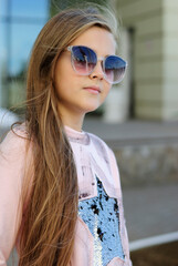 beautiful teenage girl with long hair wearing blue glasses and a plaid shirt portrait