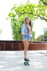 beautiful teenage girl with long hair in blue glasses and a plaid shirt on a skateboard