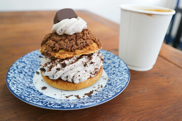 bun ,choux pastry with chocolate powder topping or eclair and hot coffee