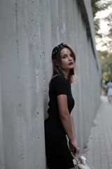 girl in a black short dress on the evening street. against the backdrop of lights, shops.