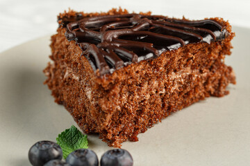 Slice of chocolate cake on plate, blueberries